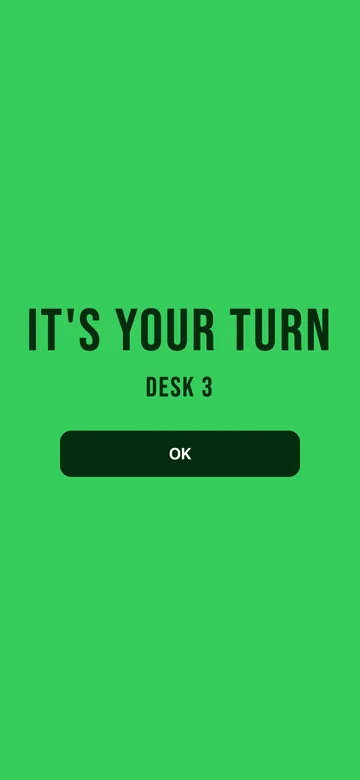 The visitor’s phone in bright green: IT’S YOUR TURN, DESK 3