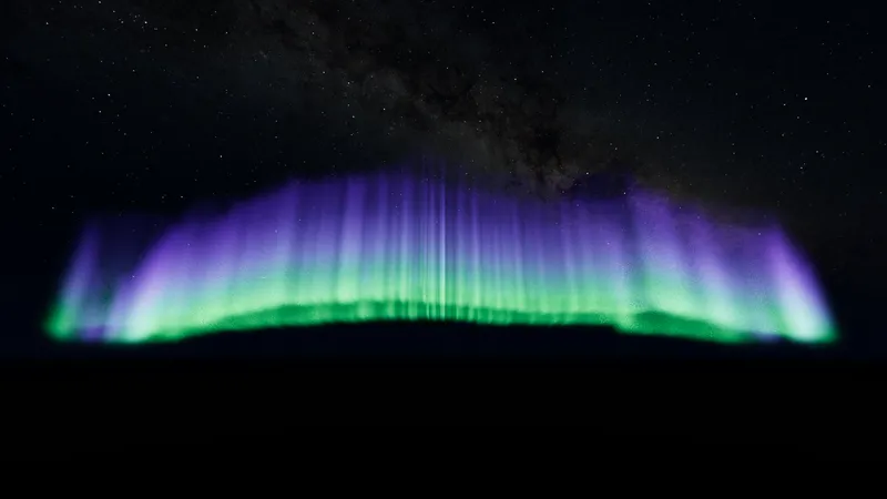 Green and violet aurora curtains under a starry sky