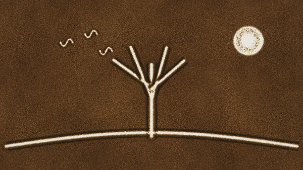 A tree, a hill and a sun drawn with light on a sand animation light table